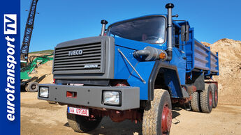 Blauer Magirus-Deutz-Kipper vor Sandgrube mit eurotransportTV-Logo am Bildrand – restaurierter Oldtimer bei strahlendem Sonnenschein.