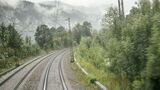 Blick auf eine zweigleisige, elektrifizierte Bahnstrecke, die durch eine neblige, bewaldete Landschaft führt. Korridorsanierungen zwingen Güterzüge teilweise zu langen Umwegen.