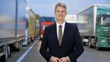Bundesverkehrsminister Patrick, Schnieder (CDU) auf einem Parkplatz voller Lkw.