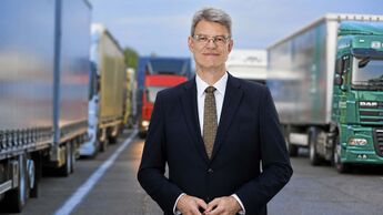 Bundesverkehrsminister Patrick, Schnieder (CDU) auf einem Parkplatz voller Lkw.
