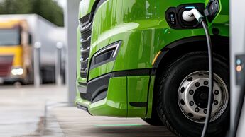 Close up of green electric truck charging at station