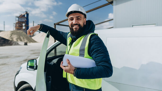 Confident,Engineer,Holding,Blueprint,While,Standing,By,His,Van,At