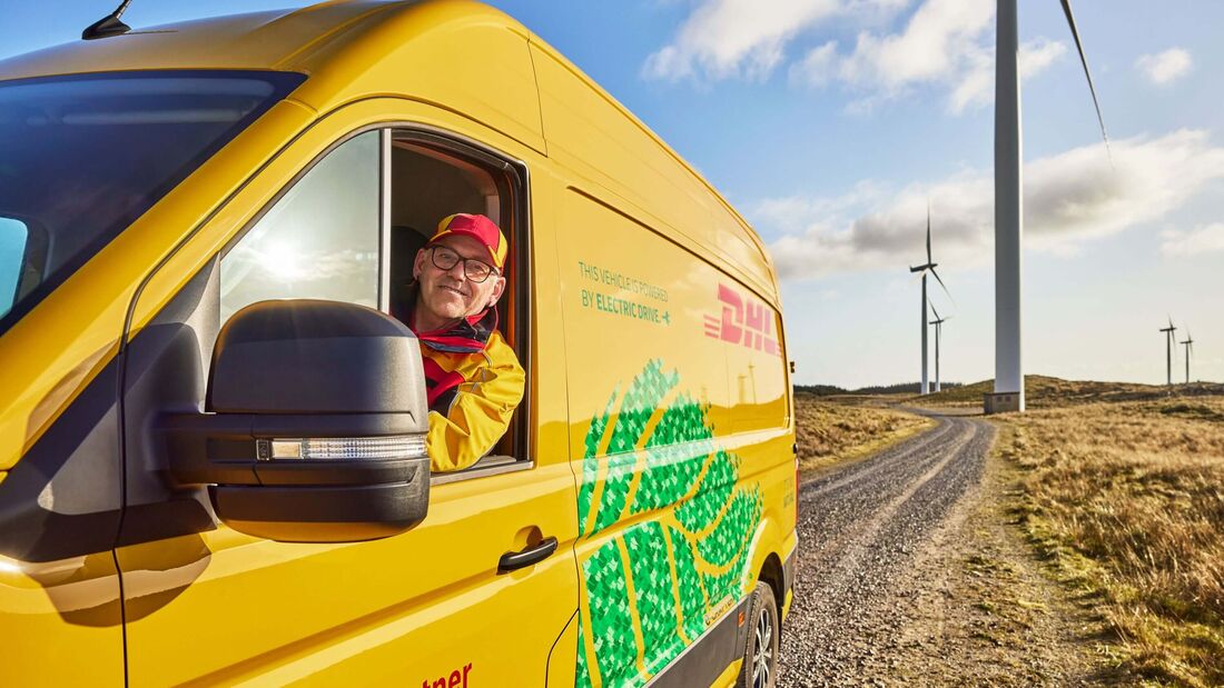 DHL-Transporter vor Windrädern. Der Logistikkonzern baut sein weltweites Netzwerk für Batterie- und Energielogistik aus.