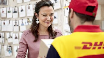 DHL-Zusteller übergibt Paket an Kundin