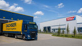 Dachser-Lkw vor einem Logistikzentrum neben einem Tesa-Gebäude als Symbol für den Wechsel der europäischen Lagerlogistik.