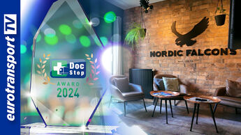 Der DocStop Award 2024 vor einer modernen Lounge mit dem Logo der Nord-Spedition Nordic Falcons im Hintergrund und dem Eurotransport TV-Logo am linken Bildrand.