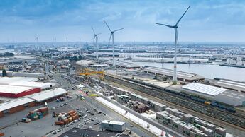 Der Portalkran am AZT-Terminal, ausgestattet für den intermodalen Containerumschlag, mit Windrädern im Hintergrund.