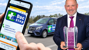 DocStop-Vorsitzender Joachim Fehrenkötter mit dem Europäischen Sicherheitspreis Nutzfahrzeuge 2026 vor einem DocStop-Motiv.