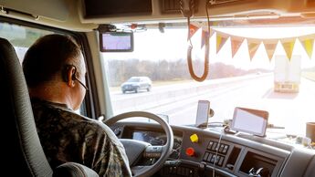 Driver in cabin of big modern truck