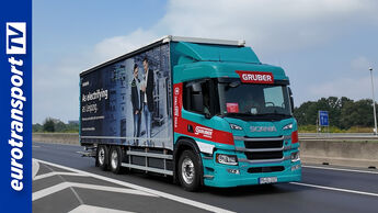 Ein Scania Elektro-Lkw P 230 von Gruber Logistics auf der Autobahn,  eurotransportTV-Logo links im Bild.