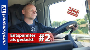 Ein entspannter Lkw-Fahrer am Steuer des Ford F-Max. Auf dem Bild ist das eurotransportTV-Logo, der Serienstempel und die Schrifteinblendung „Entspannter als gedacht? #2“ zu sehen.