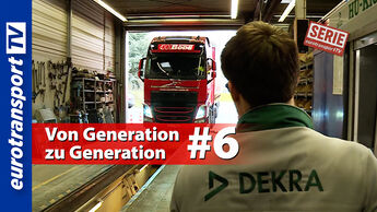 Ein junger Mitarbeiter mit DEKRA-Jacke blickt in einer Prüfhalle auf einen roten Lkw, der auf einer Prüfbahn steht. Sichtbar sind das eurotransportTV-Logo, der Serienstempel sowie die Schrifteinblendung „Von Generation zu Generation #6“.