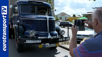 Ein restaurierter Krupp Titan Oldtimer-Lkw mit Plane und Anhänger steht auf einem Parkplatz. Helmut Hoffmann fotografiert das Fahrzeug mit dem Smartphone. Links im Bild ist das eurotransportTV-Logo zu sehen.