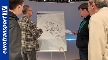 Eine Gruppe diskutiert Skizzen eines Lkw-Kabinen-Designs vor einem Flipchart, links das eurotransporttv-Logo.