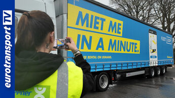 Eine Heppner-Mitarbeiterin fotografiert einen Trailer mit der Aufschrift „Miet me in a minute“, der für das digitale Mietkonzept von Fleetloop wirbt; am linken Bildrand ist das eurotransportTV-Logo sichtbar.