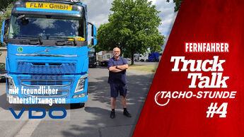 Fahrer mit verkreuzten Armen neben einem blauen Lkw