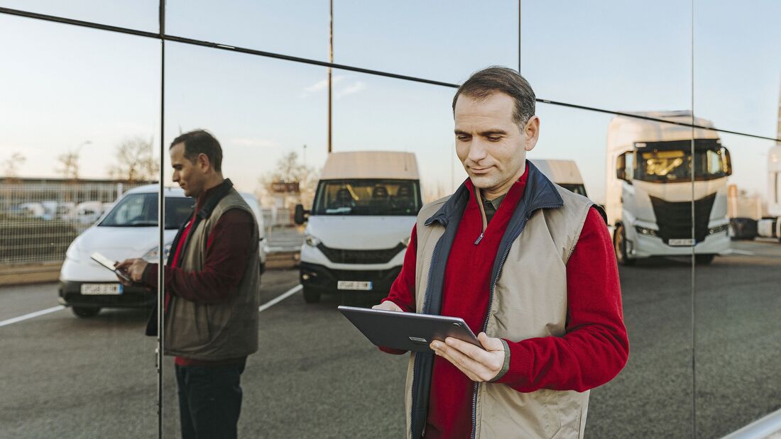 Fleet Manager mit Tablet vor Fahrzeugen