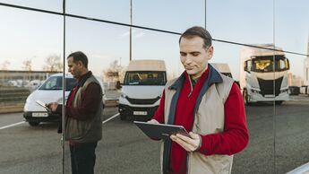 Fleet Manager mit Tablet vor Fahrzeugen