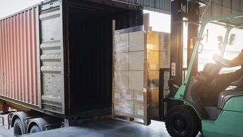 Forklift Tractor Loading Package Boxes into Cargo Container at Dock Warehouse. Delivery Service. Shipping Warehouse Logistics. Cargo Shipment. Freight Truck Transportation.