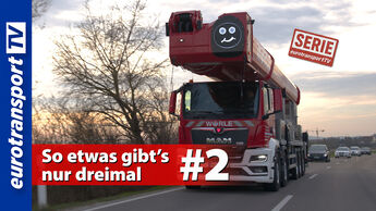 Frontansicht eines roten MAN TGS mit riesiger Arbeitsbühne auf einer Straße. Auf dem Fahrzeug ist ein Smiley zu sehen. Im Bild befinden sich das eurotransportTV-Logo, der Serienstempel sowie der Thumbnail-Text „So etwas gibt’s nur dreimal #2“.