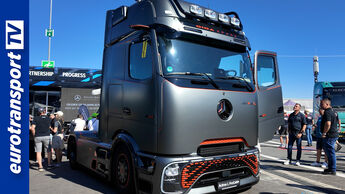 Grauer Mercedes-Benz Actros L ProCabin auf dem Truck Grand Prix, umgeben von Besuchern; links das eurotransportTV-Logo.