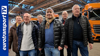 Gruppenfoto vor neuen Mercedes Benz Actros mit Joachim Fehrenkötter im Werk Wörth, links ist das eurotransportTV-Logo.
