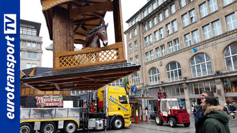 In der Essener Innenstadt bauen Dirk und Nick Obermann mit einem gelben Lkw von Auto Obermann die große Weihnachtspyramide auf. Links das eurotransportTV-Logo.