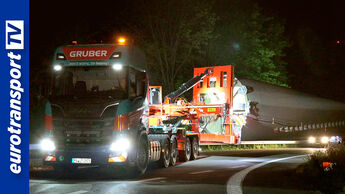 In der Nacht fährt ein Spezialtransport mit einem Rotorblatt für eine Windkraftanlage auf der Autobahn.