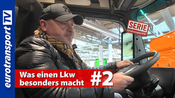 Joachim Fehrenkötter steht lächelnd in der Auslieferungshalle von Mercedes-Benz. Links im Bild das eurotransportTV-Logo, rechts oben das leuchtende Mercedes-Logo. Der Serien-Stempel „Serie eurotransportTV“ ist eingeblendet. Schrifteinblendung: „Was einen Lkw besonders macht #2“.