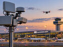 KI-generiertes Symbolbild einer Drohne über einem Flughafen mit technischer Drohnendetektion im Vordergrund.