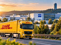 KI-generiertes Symbolbild mit gelbem DHL-Lkw vor einem modernen Technologiecampus mit Zeiss-Schriftzug. Das Motiv illustriert die Hightech-Strategie von DHL Supply Chain in der Region Jena.