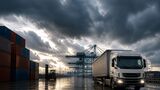 Lkw im Industriehafen unter dunklem Himmel als Symbol für wirtschaftlichen Abschwung in der Logistik