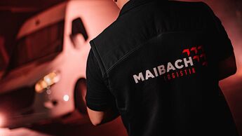 Maibach-Logistik Transporter und Fahrer bei Nacht