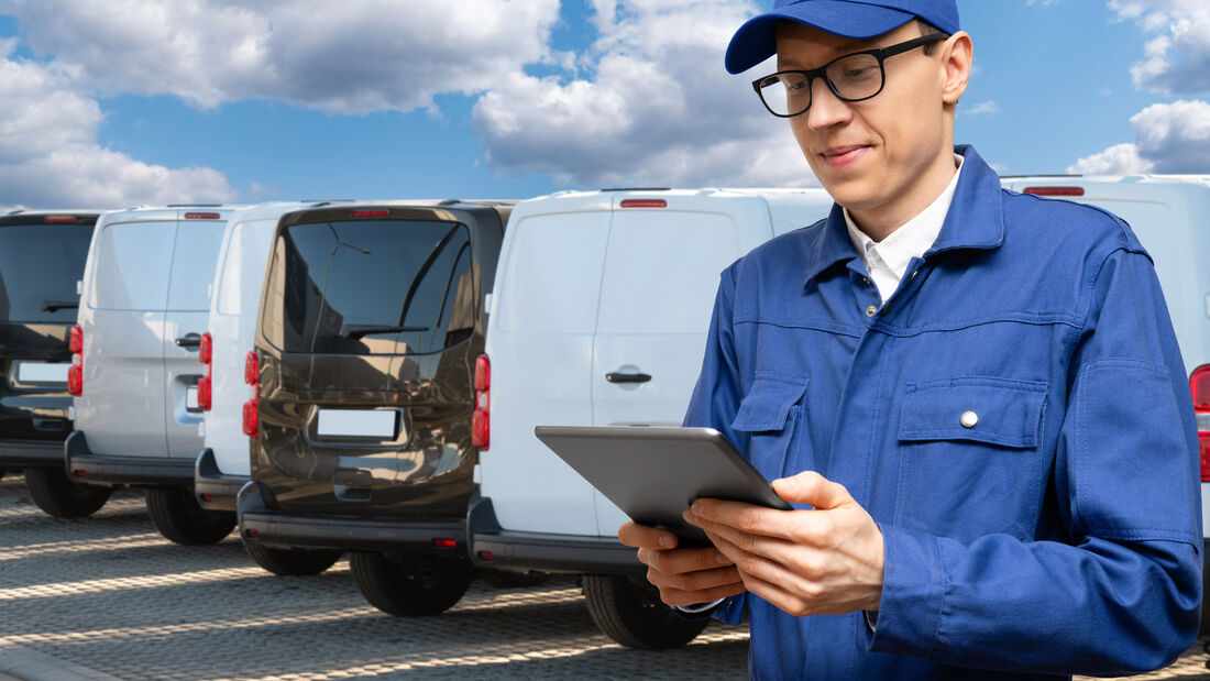 Manager,With,A,Digital,Tablet,On,The,Background,Of,Vans.