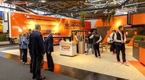 Mehrere Personen stehen auf dem Messestand von Trailer Dynamics auf der IAA Transportation in Hannover.