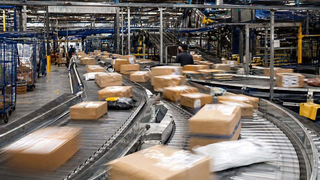 Pakete auf Förderband in Logistikzentrum mit hoher Auslastung in der Paketlogistik