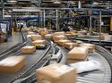 Pakete auf Förderband in Logistikzentrum mit hoher Auslastung in der Paketlogistik