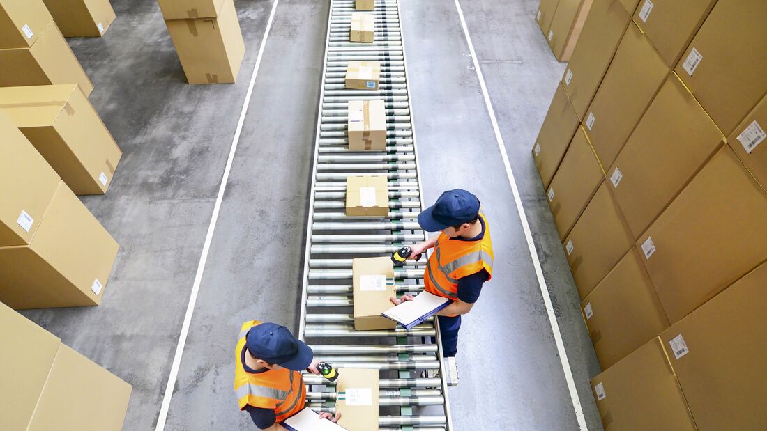 Pakete und arbeiter im Warenversand eines Onlinehandels