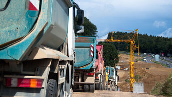 Row of dum trucks being parked at a highway construction site in Germany