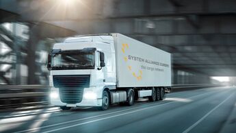 Truck driving on a road through an industrial style bridge