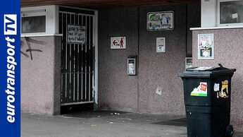 Verschlossene Toilettenanlage an einem Rastplatz mit Mülleimer davor; links das eurotransportTV-Logo.