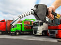 Zapfpistole in Hand im Hintergrund div. LKW