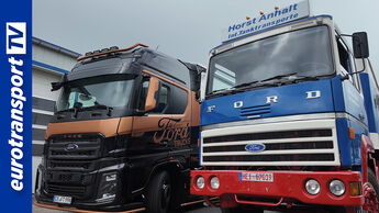Zwei Ford-Lkw-Generationen nebeneinander: links der moderne F-MAX in der Select-Version, rechts ein Ford Transcontinental von 1982 im klassischen Design. Im Hintergrund eine Werkstatthalle, links unten das eurotransportTV-Logo.