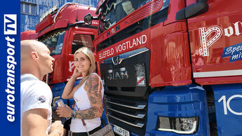 Zwei junge Menschen stehen vor einem MAN-Truck der Spedition Poller und unterhalten sich. Im Hintergrund weitere rot-blaue Lkw mit dem Schriftzug „Poller Spedition“. Links im Bild gut sichtbar das vertikale eurotransportTV-Logo.