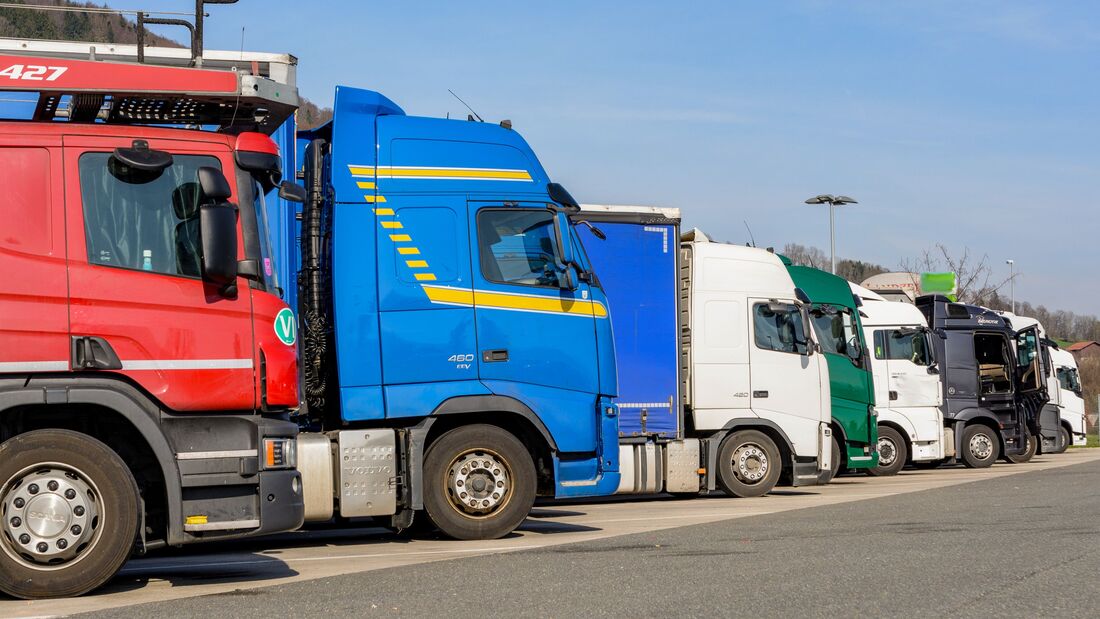 bunte Ansammlung von zahlreich geparkten LKWs an einem Autobahnparkplatz
