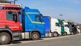 bunte Ansammlung von zahlreich geparkten LKWs an einem Autobahnparkplatz