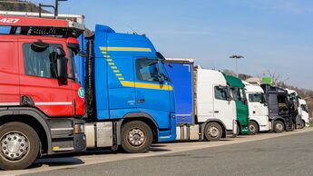 bunte Ansammlung von zahlreich geparkten LKWs an einem Autobahnparkplatz